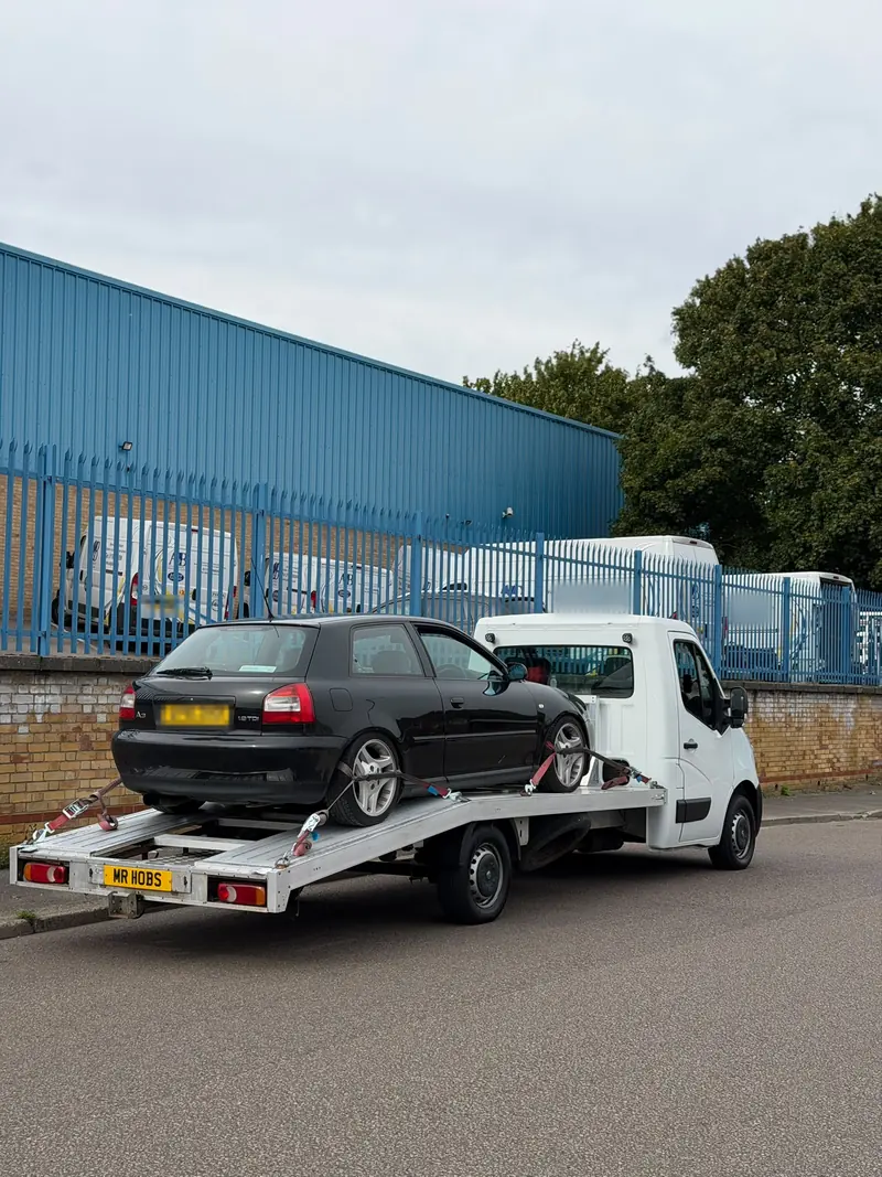 Black Audi A3 on the recovery truck on an industrial estate